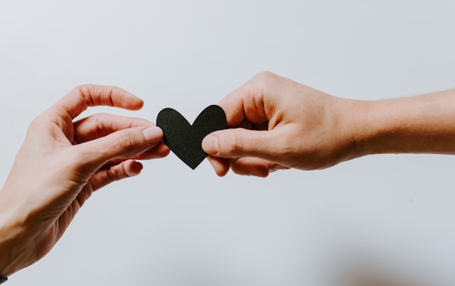 Two hands with black heart