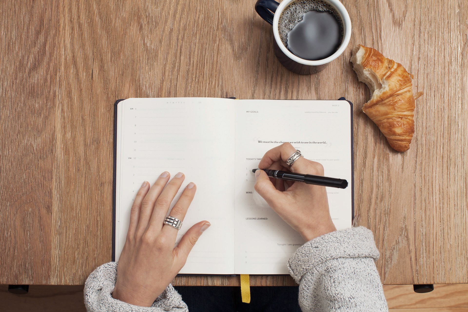 Person writing on book for time management and planning 