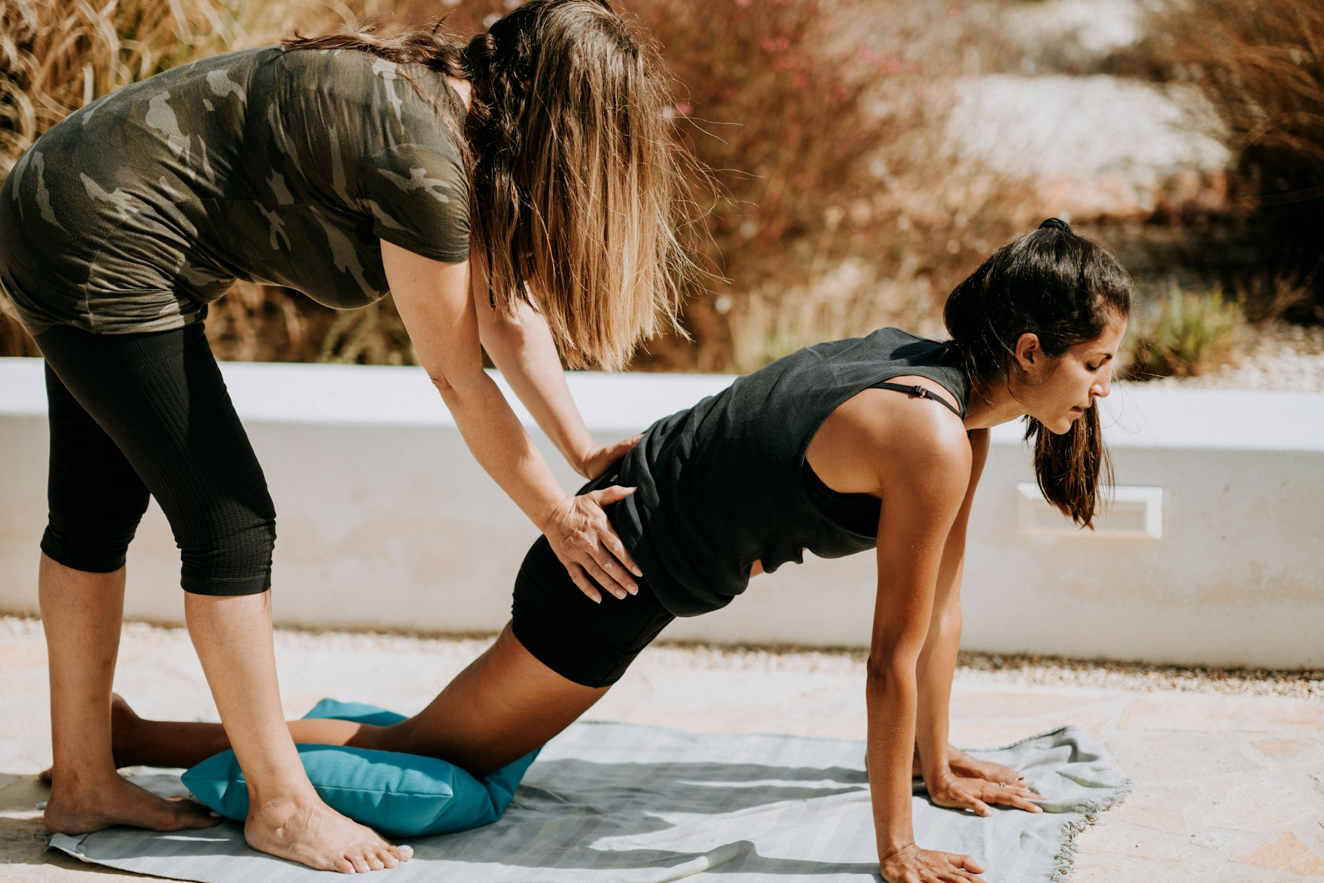 Yoga Woman being helped by mentor or teacher which shows leadersip